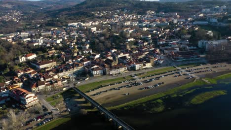 Puente-Peatonal-Que-Cruza-El-Río-Conduce-A-La-Ciudad-De-Ponte-De-Lima,-El-Pueblo-Más-Antiguo-De-Portugal,-Antena-Panorámica-Establecida-En-La-Hora-Dorada