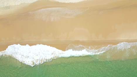 top down drone view over waves in turquoise ocean