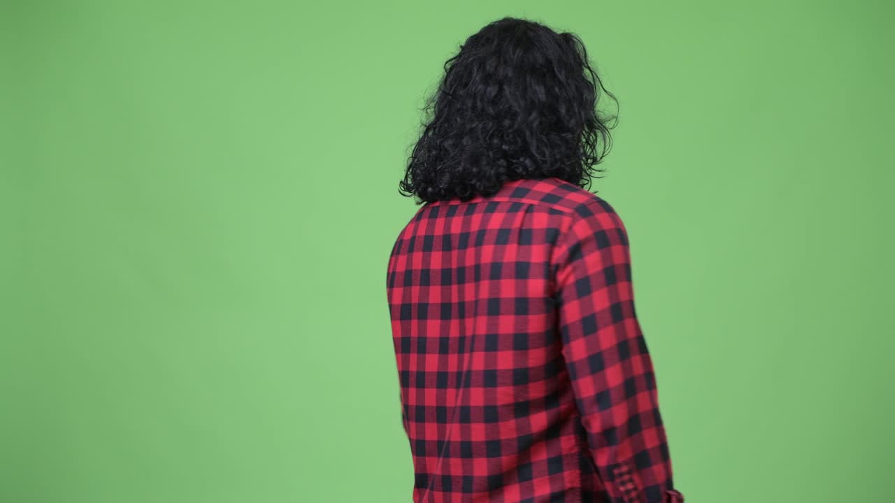 Homem hipster bonito virando-se e depois sorrindo com os braços cruzados
