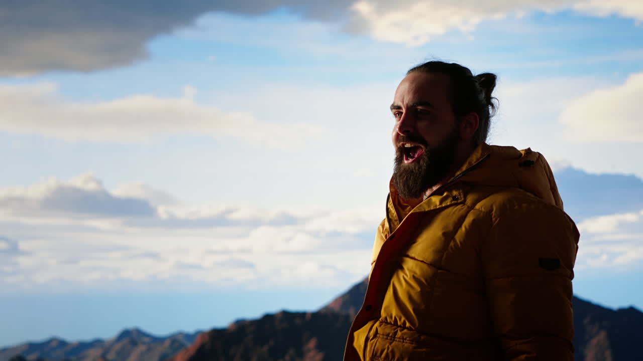 un excursionista estirando sus brazos en la emoción en la cima de la cordillera