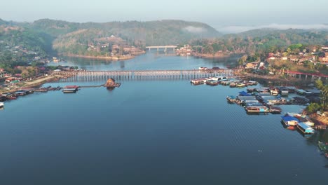 a panoramic view of the khwae noi river, featuring the mon bridge and the songkalia bridge, capturing the scenic beauty of songklaburi, thailand