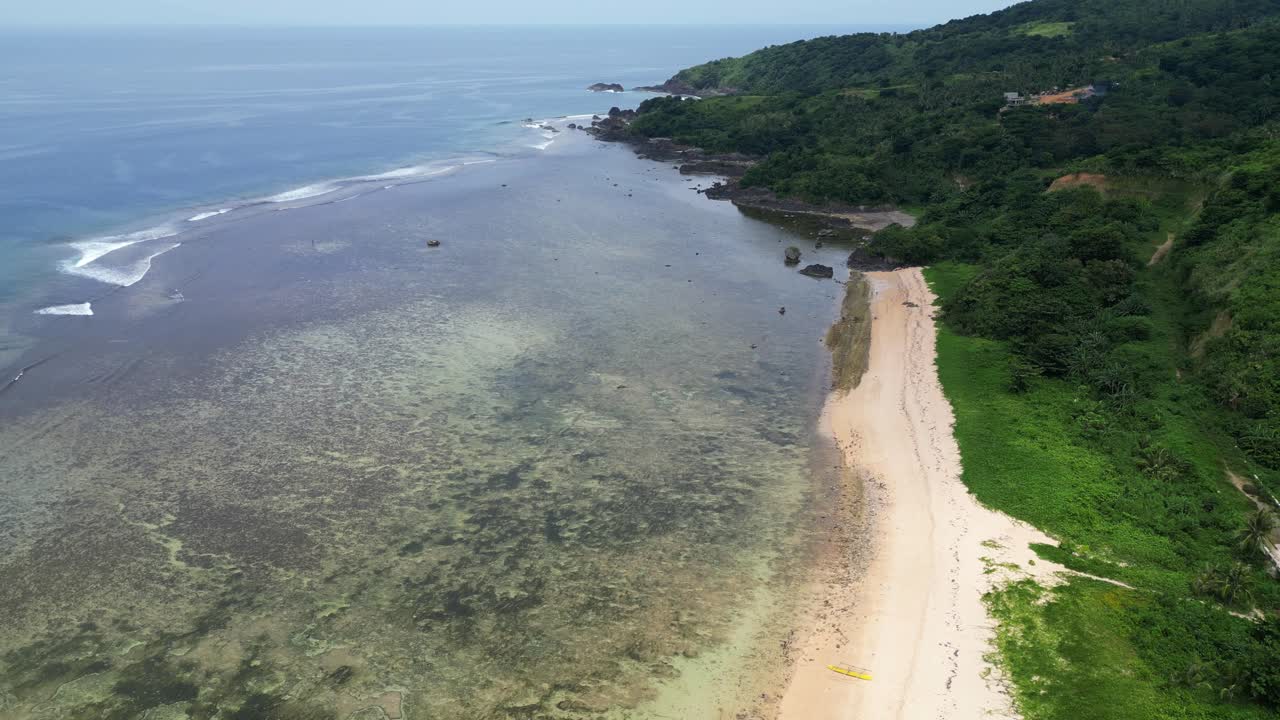 puraran baras con aguas claras, arrecifes de coral, playa de arena y vegetación exuberante, vista aérea