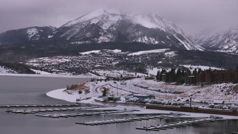 lake dillon marina keystone summit cove colorado aerial cinematic drone cloudy snowy winter morning view frisco breckenridge silverthorne ten mile range peaceful calm unfrozen ice backward motion