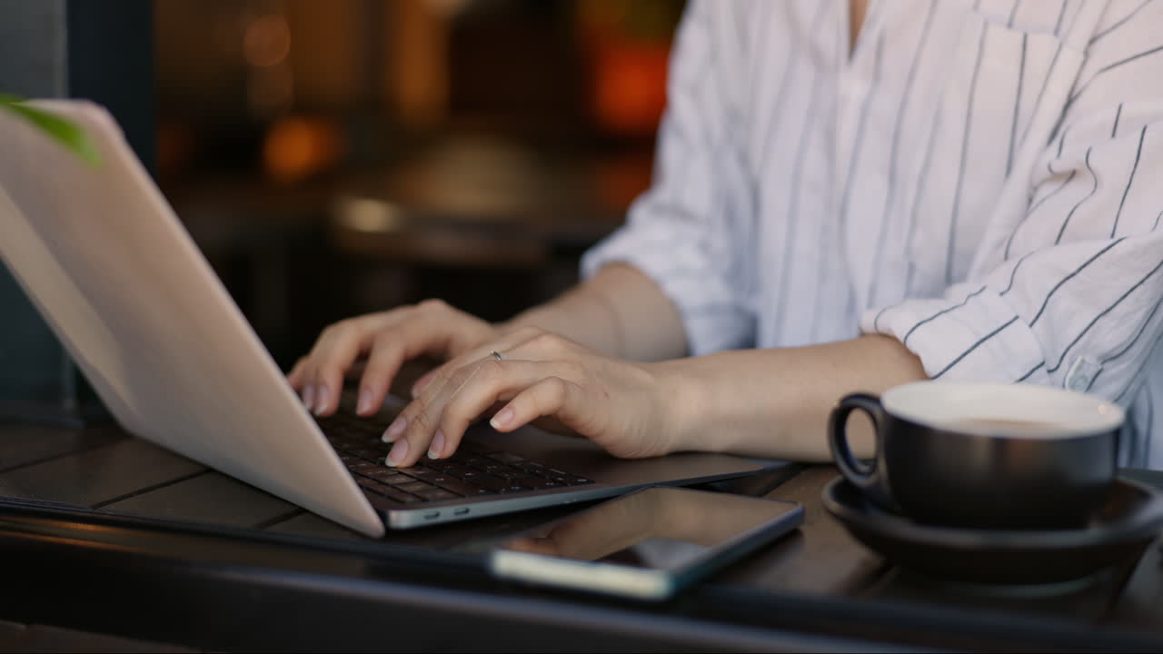 Woman Working on Laptop in a Cafe