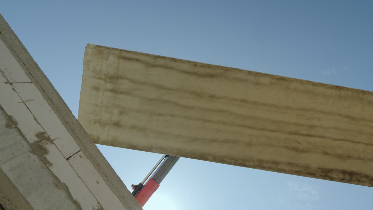 대형 철근 콘크리트 슬래브가 크레인의 붐에 매달려 있다