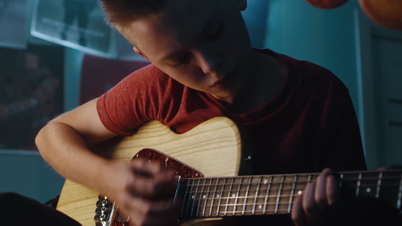 Teenager Playing Electric Guitar in Bedroom