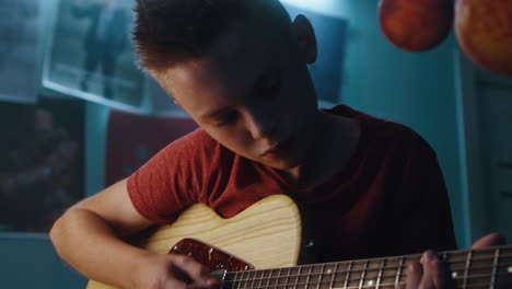 teenager playing electric guitar in bedroom
