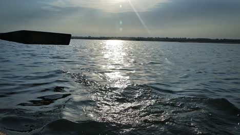 person paddling during sunrise on the water of river ganges in varanasi city, state of uttar pradesh, india. - close up shot
