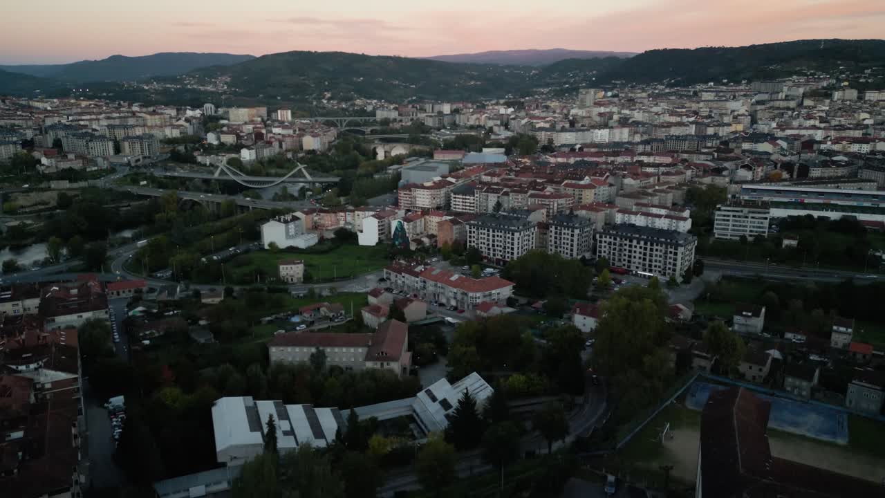 Aerial descend above apartment building homes in Ourense Spain at sunset