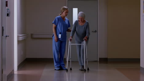 nurse assisting elderly patient with a walker in a hospital hallway