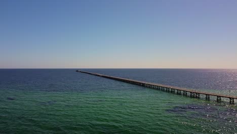 long pier extending into the clear ocean