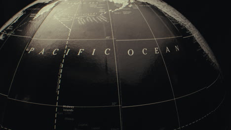 close-up of a vintage world globe, focusing on the pacific ocean region.
