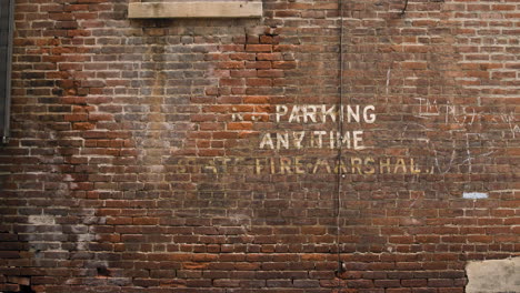 Brick-Wall-with-Painted-No-Parking-Anytime---Fire-Marshal-Sign
