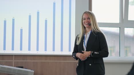 Entrenadora-De-Negocios-Femenina-Está-Actuando-En-Una-Conferencia-En-Una-Gran-Empresa-De-TI-Especialista-En-Mujeres-Positivas