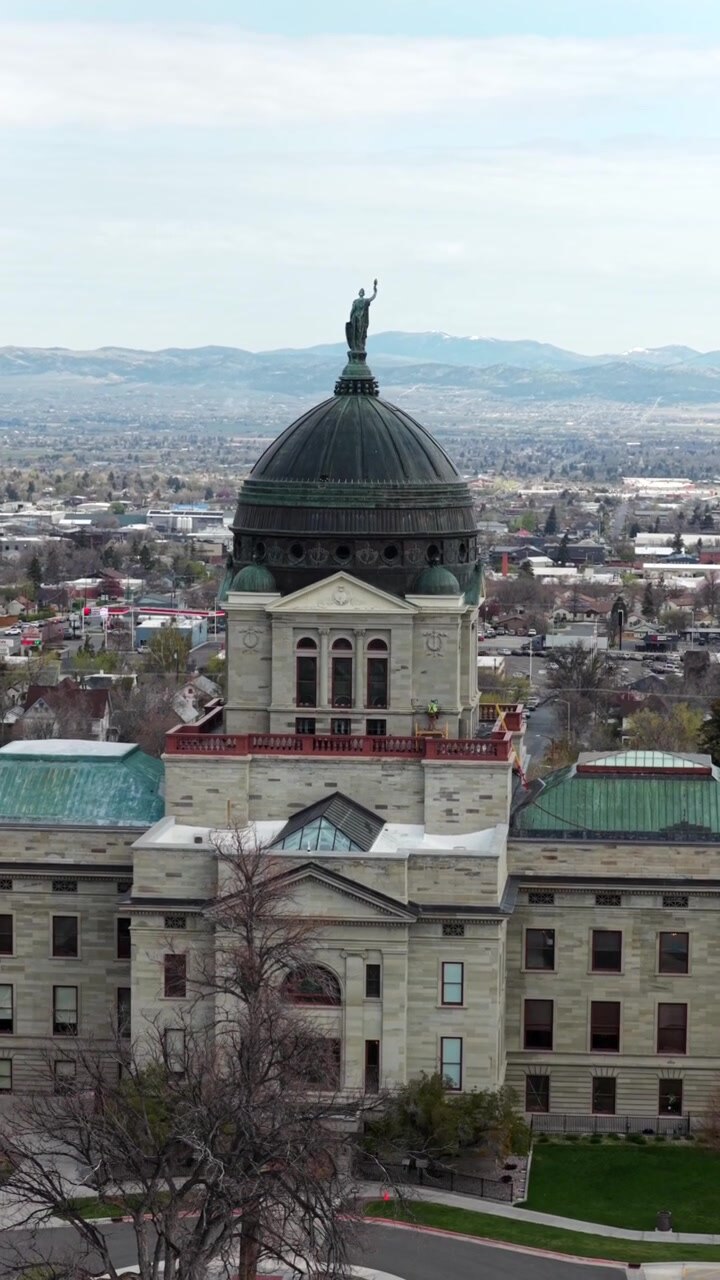 Edifício do Capitólio Estadual de Montana em Helena, Montana, apresentando arquitetura de cúpula histórica e arredores do distrito governamental. Imagem aérea vertical de drone. Dia nublado em uma cidade americana.