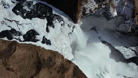 Top-down-view-of-frozen-and-snowy-Skogafoss-waterfall-in-Iceland