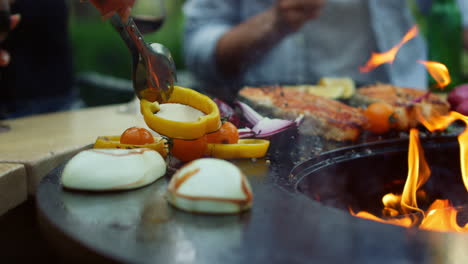 unrecognizable women turning vegetables outside. girls cooking vegetarian food