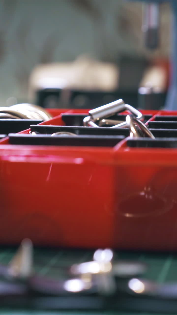 CU: Professional designer takes various accessories from red box and puts on cutting mat in workshop close view