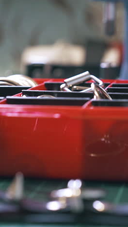 cu: professional designer takes various accessories from red box and puts on cutting mat in workshop close view