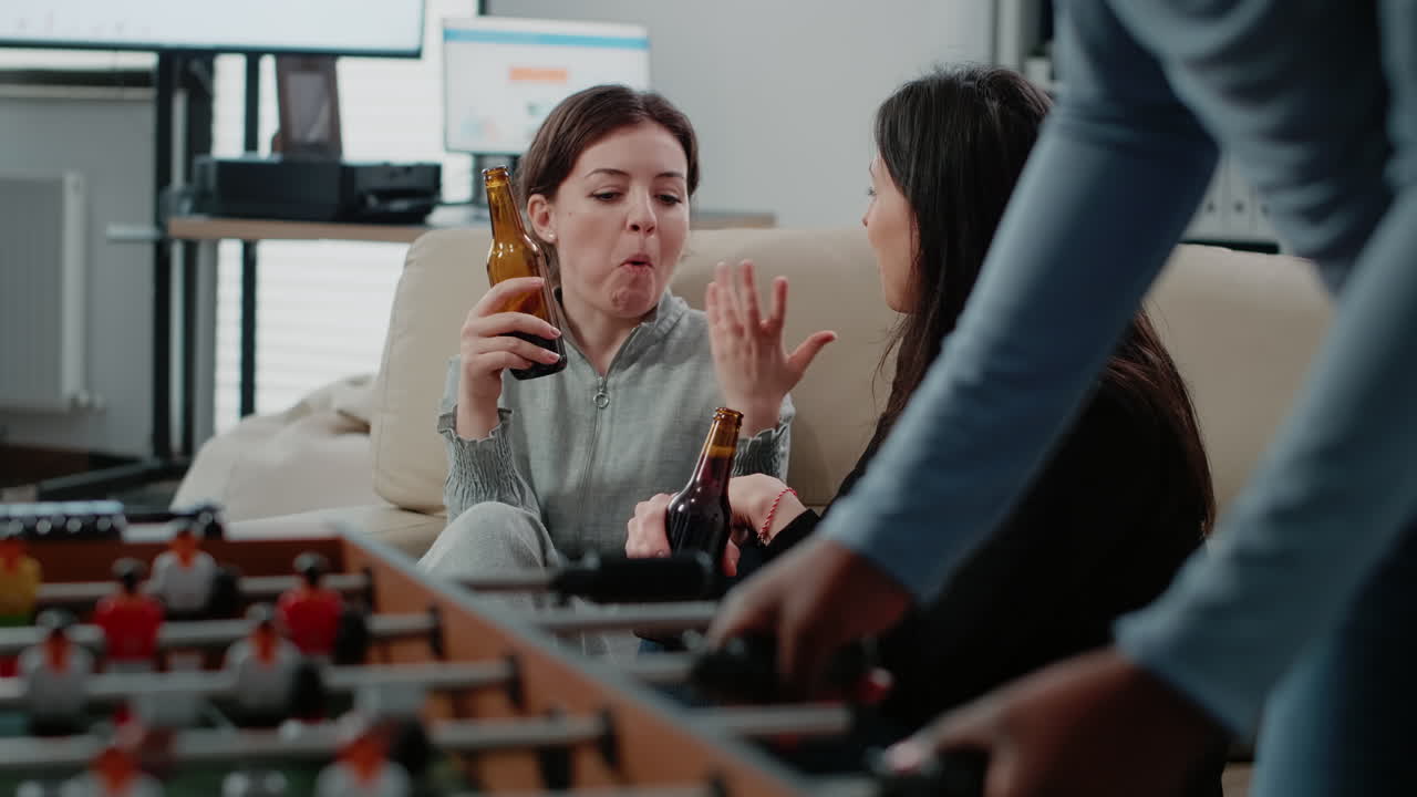Close up of women with bottles of beer and snacks talking