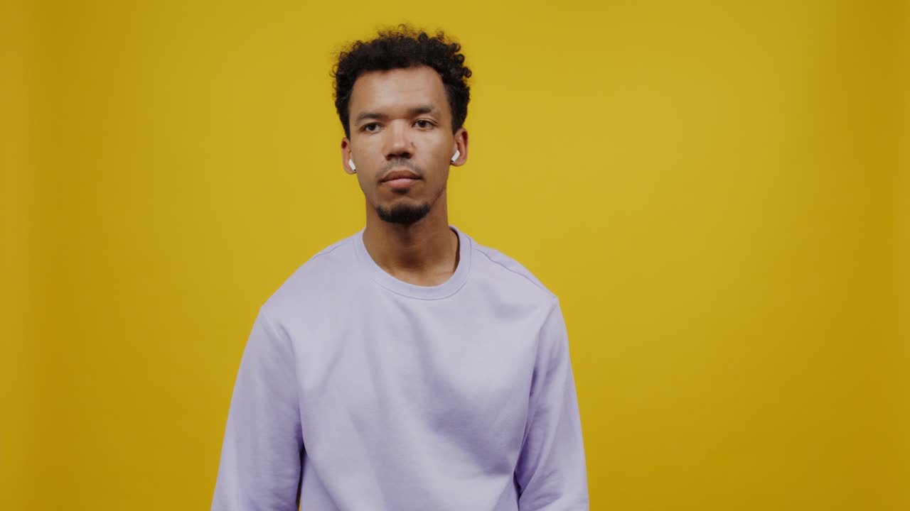 Man wearing purple sweatshirt and earbuds