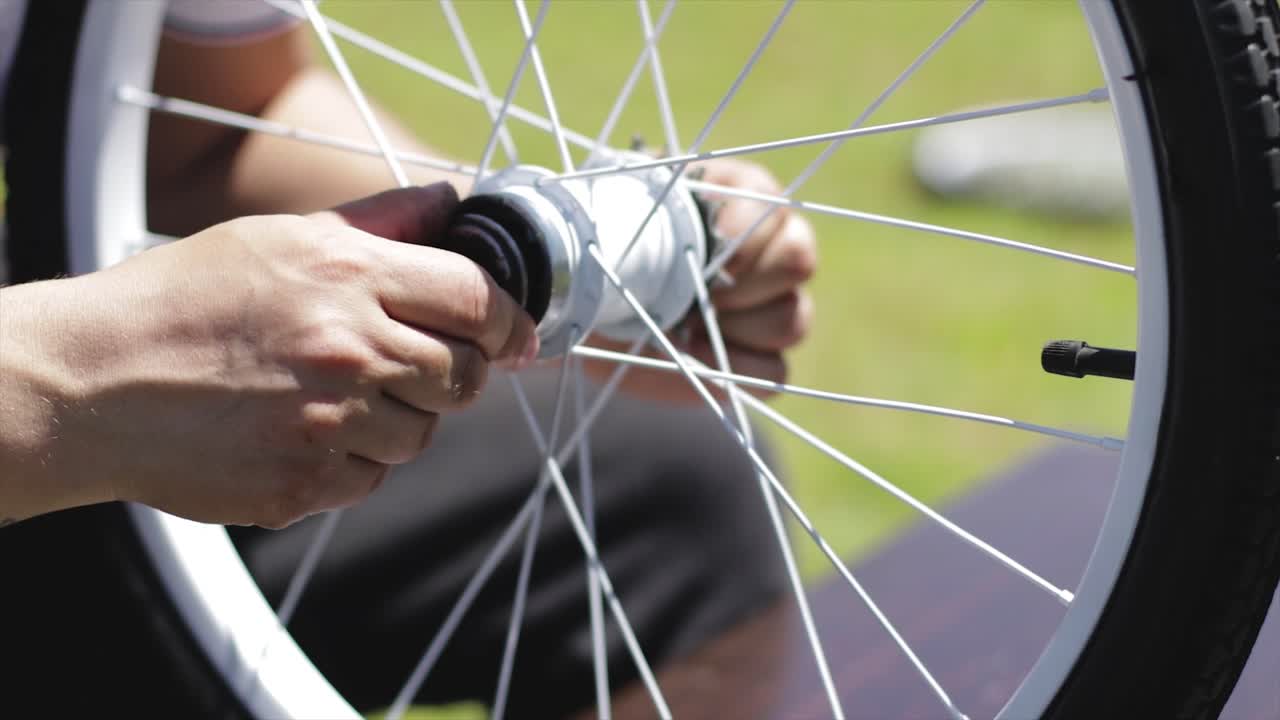 Placing new bearings on the axis of a bicycle wheel. Person repairing an old bike. Bicycle restoration
