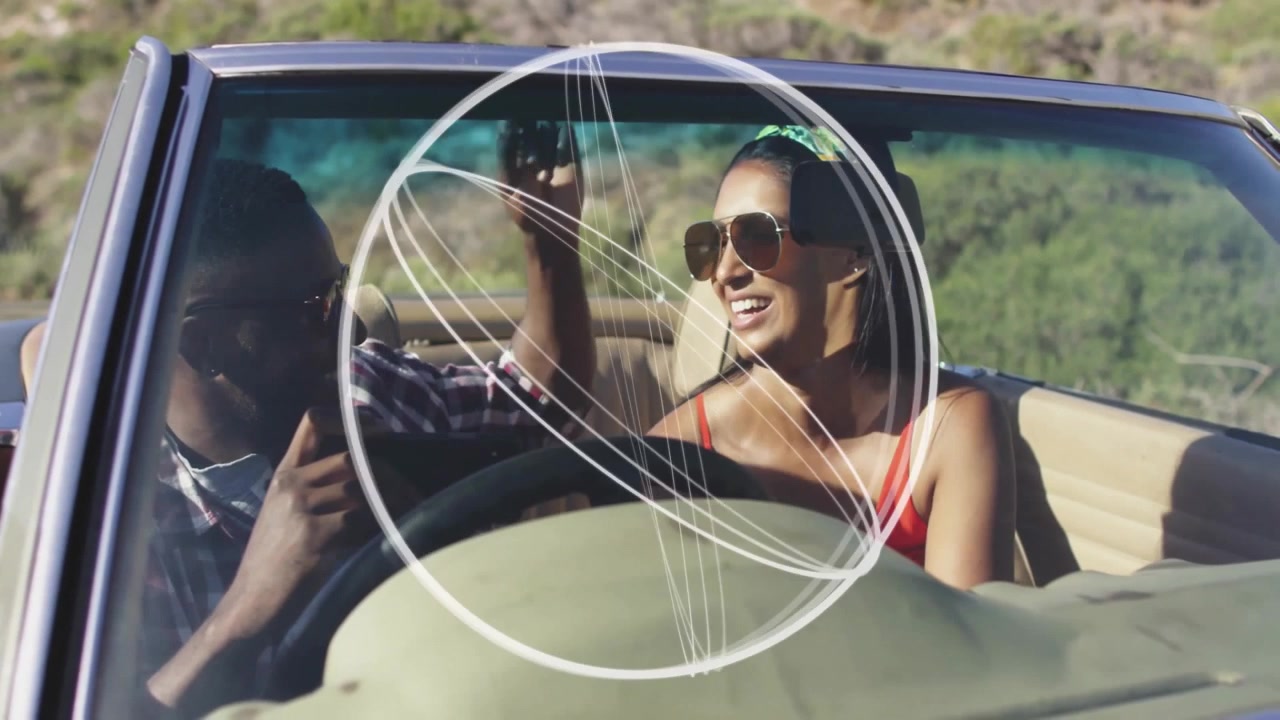 Female driver and passenger exchanging marketing stats on rural road, with tech icons floating