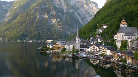 beautiful cinematic shot flying away from picturesque church in hallstatt, austria