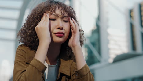 woman experiencing headache outdoors