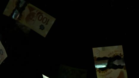 falling flying american canadian dollar banknotes on a black background in 4k loopable. high quality falling dollar banknotes in 4k. video is loopable