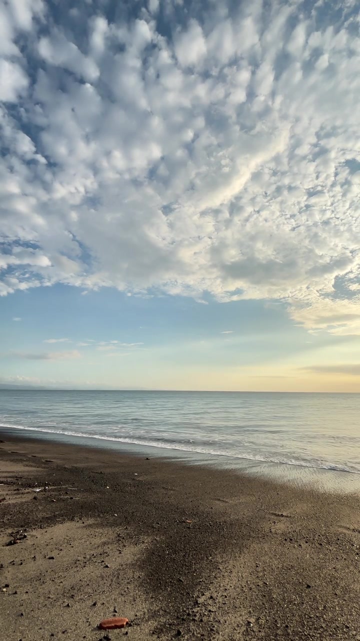 Scena di spiaggia tranquilla con onde leggere e cielo nuvoloso