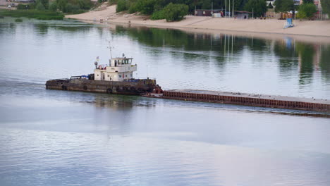 tug flowing along river daylight drone shot. tow boat pushing old empty barge.