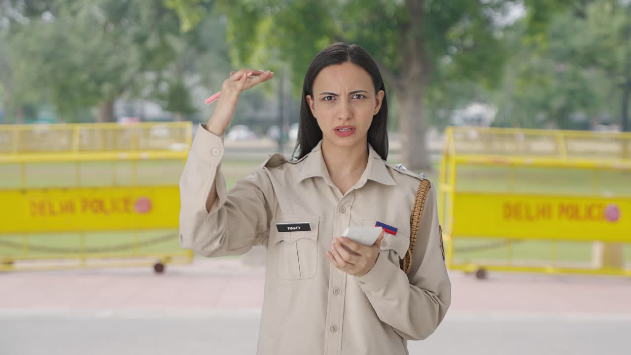 인도 여성 경찰관이 사건의 세부 사항을 쓰고 있습니다.
