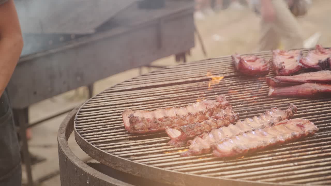 요리사는 손으로 그릴 고기를 바로잡습니다.