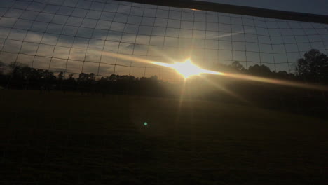 sunset through a soccer goal post