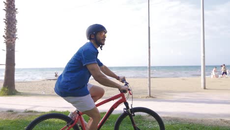 young man riding a bike on the beach.