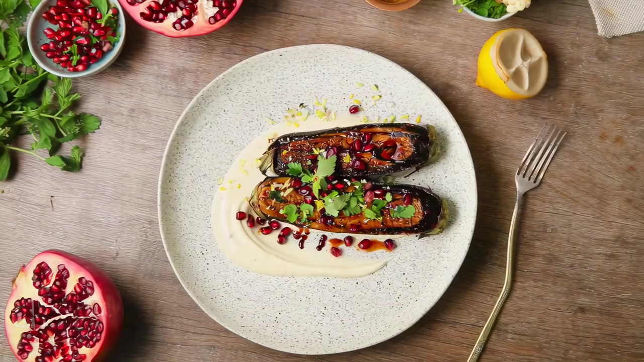 Preparazione e impiattamento di deliziose melanzane fritte in padella con melograno e tahini