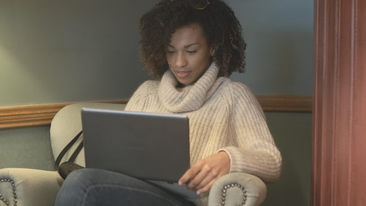 Casual student woman sitting at coffee shop and using laptop
