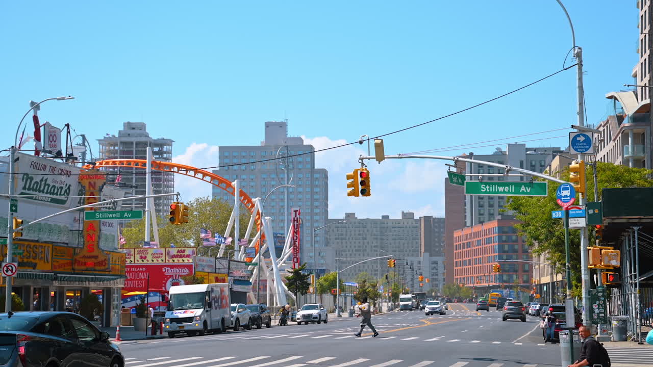 New York, USA, 1 August 2025: Stillwell Avenue sign at Coney Island. Street view of Stillwell Avenue with Nathan's Famous and amusement rides in Coney Island, Brooklyn