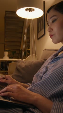 mujer trabajando en una computadora portátil en casa