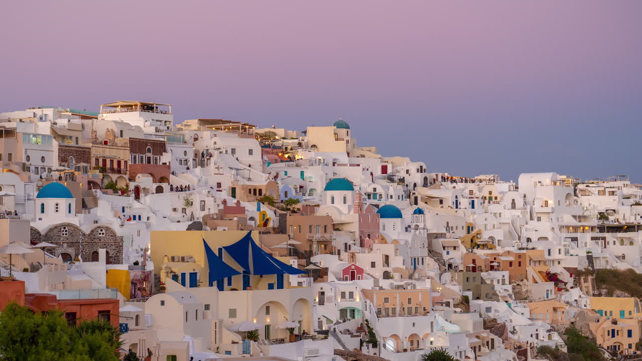timelapse, puesta de sol en la isla de santorini, edificios de la aldea de oia y cielo púrpura