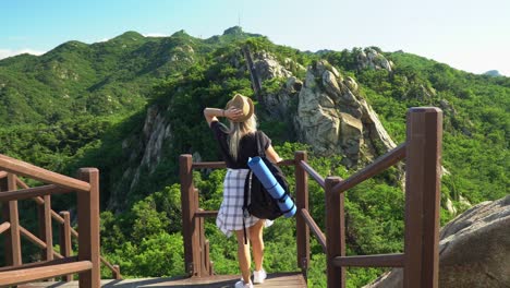 Millennial-girl-has-a-carefree-moment-enjoying-green-mountains-during-hike