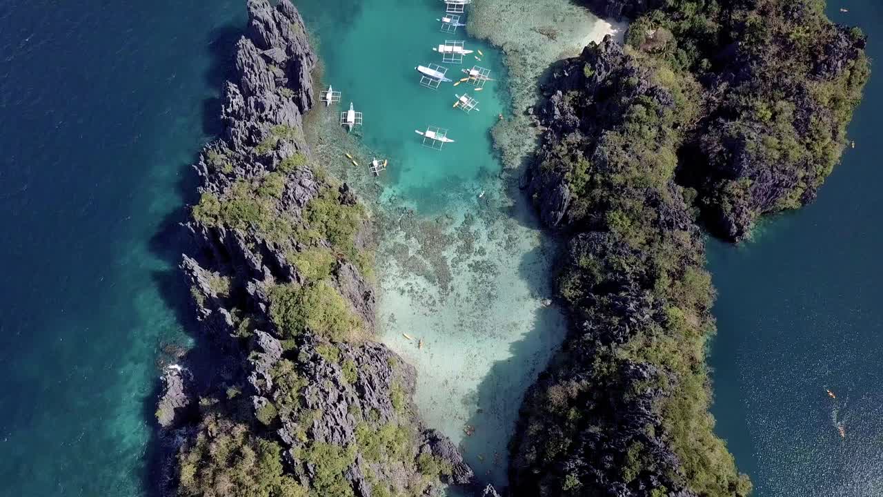 Vista aerea con drone 4K di barche in una piccola laguna a Palawan, Filippine