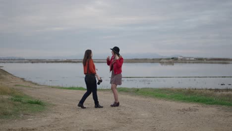 two women taking photos outdoors