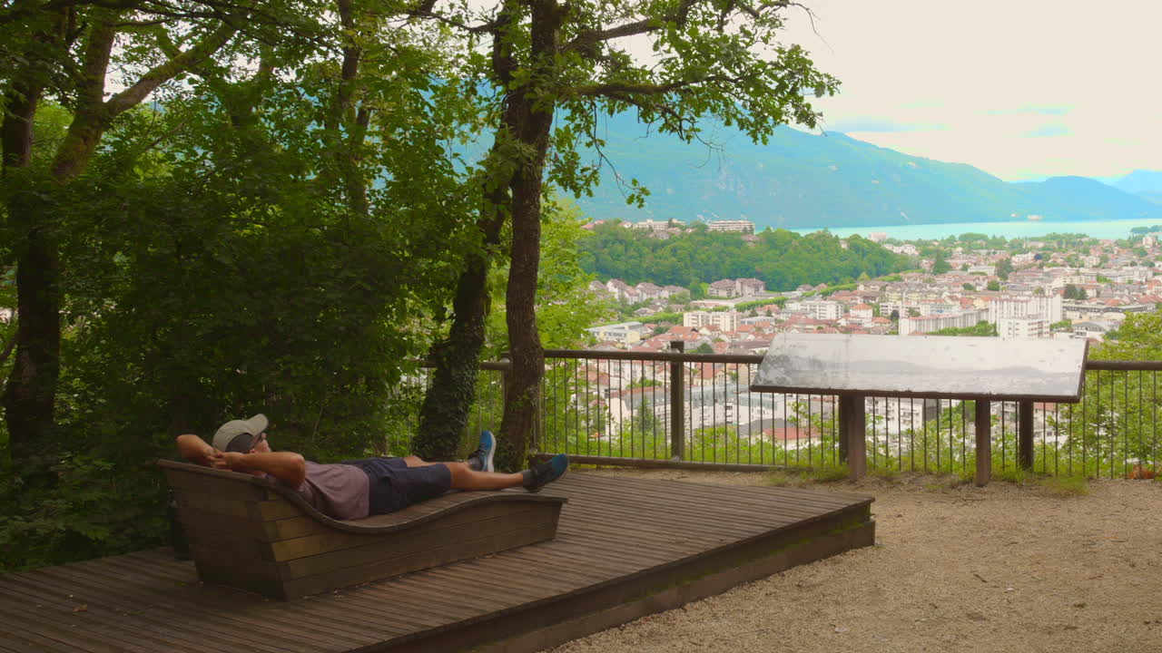 Man resting in area with panoramic view of Aix-les-Bains, France.