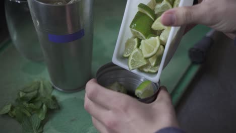 unrecognizable bartender adding lime slices in cynar drink