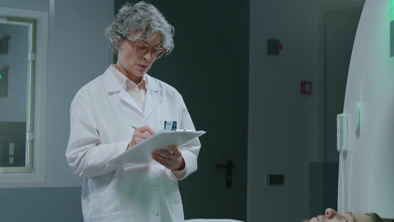 Paciente en camilla de escáner, hablando con doctor antes de resonancia magnética.