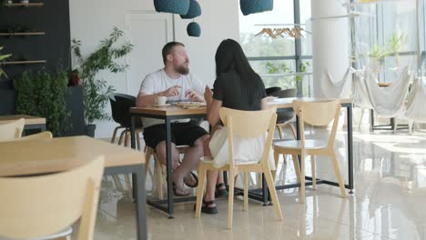 una pareja comiendo pizza en un restaurante.