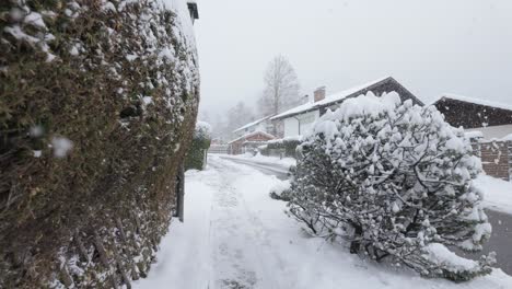 person's pov walking in the snowy sidewalk during snowfall