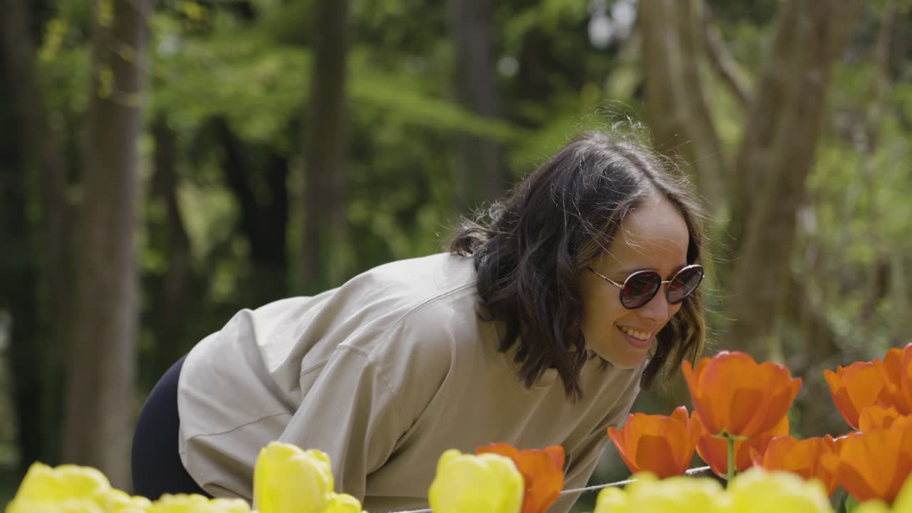 Slowmotion bokeh shot of a woman smiling and enjoying looking at the Tulips in Kyoto